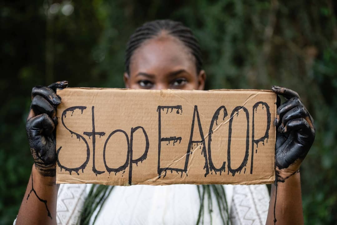 Girl holding a sign with tarred hands